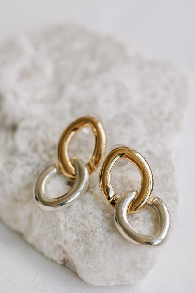 Gold and Silver Earrings on a Rock